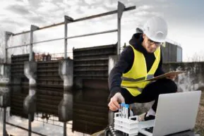 full-shot-engineer-with-laptop-outdoors_23-2149354034